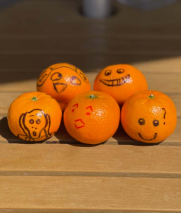 Five Cutie Tangerines with faced drawn on them in sharpie